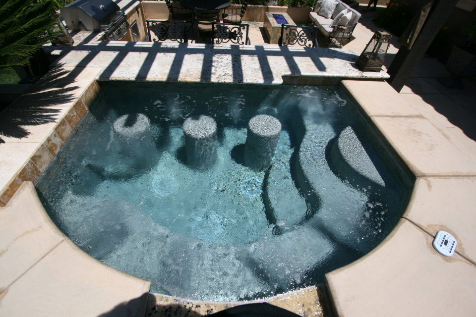 Custom spa with in-spa stools attached to a sunken outdoor bar. Built by Paradise Pools & Spas.