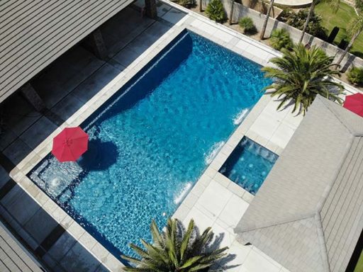 Aerial view of a beautiful Bakersfield pool and spa, accented by a large red umbrella.